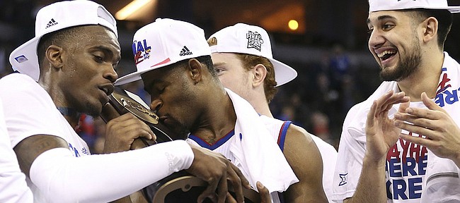 Kansas guard Malik Newman (14) kisses the Midwest Regional trophy as the Jayhawks celebrate a trip to the Final Four following their 85-81 overtime victory over Duke on Sunday in Omaha, Neb.