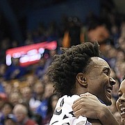 Kansas senior guard Devonte' Graham smiles with transfers Dedric Lawson and Charlie Moore after a missed chance by Mitch Lightfoot during an exhibition game Tuesday against Pittsburg State at Allen Fieldhouse.