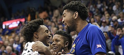 Kansas senior guard Devonte' Graham smiles with transfers Dedric Lawson and Charlie Moore after a missed chance by Mitch Lightfoot during an exhibition game Tuesday against Pittsburg State at Allen Fieldhouse.