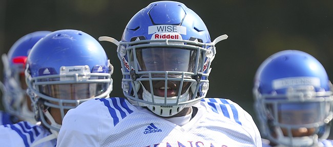 Kansas defensive tackle Daniel Wise and other members of the defense watch over a drill during practice on Tuesday, April 10, 2018.