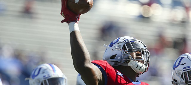 Kansas defensive end Dorance Armstrong Jr. (2) hoists up the ball after recovering a fumble during the third quarter on Saturday, Oct. 7, 2017 at Memorial Stadium.
