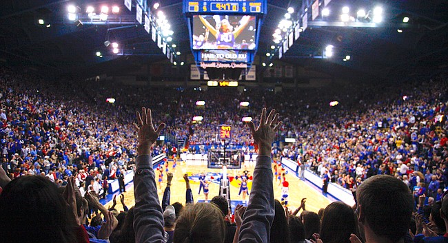 Fans raise their hands during the playing of the Alma Mater on Saturday, Dec. 15, 2012 at Allen Fieldhouse.