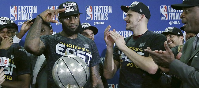 Cleveland Cavaliers forward LeBron James salutes after his team was presented the trophy for beating the Boston Celtics 87-79 in Game 7 of the NBA basketball Eastern Conference finals, Sunday, May 27, 2018, in Boston. (AP Photo/Elise Amendola)

