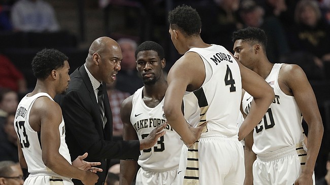 FILE — Wake Forest head coach Danny Manning, second from left, talks to his team during the first half of an NCAA college basketball against Tennessee in Winston-Salem, N.C., Saturday, Dec. 23, 2017. (AP Photo/Chuck Burton)