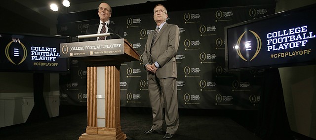 FILE — Bowl Championship Series executive director Bill Hancock, left, and former Arkansas athletic director Jeff Long, chairman of the College Football Playoff Committee, announce the 12 members selected to the committee during a news conference, Wednesday, Oct. 16, 2013, in Irving, Texas. The University of Kansas announced Long as its new athletic director on July 5, 2018. (AP Photo/Tony Gutierrez)

