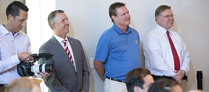 Kansas head basketball coach smiles next to assistant athletic director Sean Lester as new University of Kansas athletic director Jeff Long speaks to those gathered for his introductory news conference on Wednesday, July 11, 2018 at the Lied Center Pavilion.