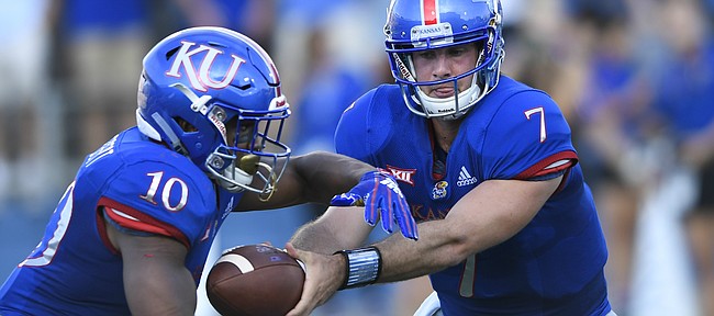 Kansas quarterback Peyton Bender (7) hands off to running back Khalil Herbert (10) during the first quarter of an NCAA college football game in Lawrence, Kan., Saturday, Sept. 1, 2018. (AP Photo/Reed Hoffmann