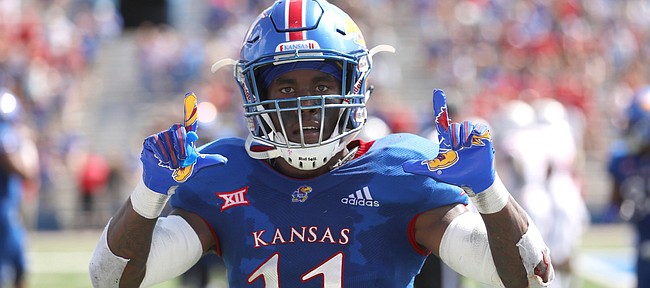 Kansas safety Mike Lee (11) celebrates before the cameras after returning an interception for a touchdown during the second quarter on Saturday, Sept. 15, 2018 at Memorial Stadium.