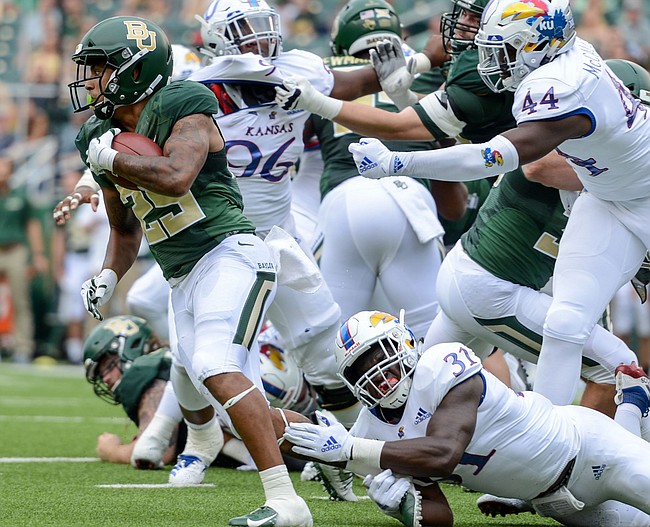 Kansas linebacker Osaze Ogbebor (31) trips down Baylor running back Trestan Ebner (25) during the first half of an NCAA college football game, Saturday, Sept. 22, 2018, in Waco, Texas. 