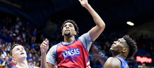 Kansas junior forward Dedric Lawson floats a shot between Mitch Lightfoot and Silvio DeSousa during Late Night in the Phog, on Sept. 28, 2018, at Allen Fieldhouse.