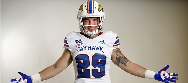 Kansas redshirt senior linebacker Joe Dineen shows off the Jayhawks' special alternate uniforms that pay homage to veterans of World War II. KU will wear the uniforms for its annual "Salute to Service" game on Nov. 3, versus Iowa State.