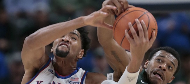 Kansas forward Dedric Lawson (1) fights for a rebound with Michigan State forward Xavier Tillman (23) during the first half of an NCAA college basketball game at the Champions Classic on Tuesday, Nov. 6, 2018, in Indianapolis.