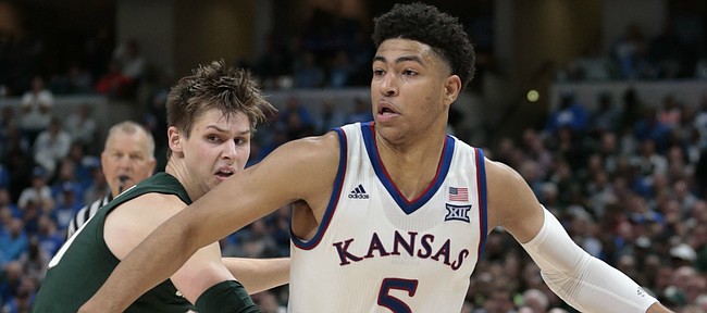 Kansas guard Quentin Grimes (5) goes around Michigan State guard Matt McQuaid (20) in the second half of an NCAA college basketball game at the Champions Classic on Tuesday, Nov. 6, 2018, in Indianapolis. Kansas won. 92-87.