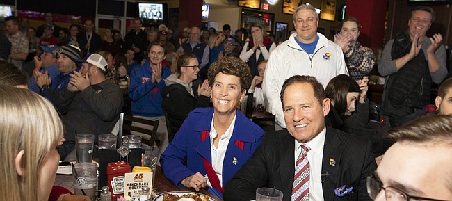 Newly-hired Kansas head football coach Les Miles sits next to his wife, Kathy, as they listen to Kansas Athletic Director Jeff Long tell a story about hiring Miles during the "Hawk Talk" radio show on Sunday, Nov. 18, 2018, at Johnny's West in Lawrence. Miles was announced as the head coach earlier in the day.