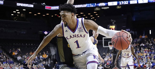 Kansas' Dedric Lawson (1) drives past Marquette's Joey Hauser (22) during the first half of an NCAA college basketball game in the NIT Season Tip-Off tournament Wednesday, Nov. 21, 2018, in New York. 