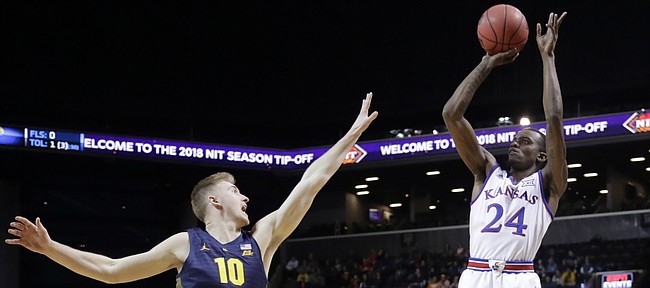 Kansas' Lagerald Vick (24) shoots over Marquette's Sam Hauser (10) during the first half of an NCAA college basketball game in the NIT Season Tip-Off tournament Wednesday, Nov. 21, 2018, in New York. 
