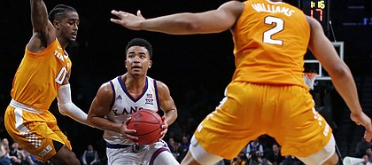 Kansas guard Devon Dotson drives to the basket between Tennessee's Jordan Bone (0) and Grant Williams (2) during the first half of an NCAA college basketball game in the NIT Season Tip-Off tournament Friday, Nov. 23, 2018, in New York. Kansas defeated Tennessee 87-81 in overtime. (AP Photo/Adam Hunger)