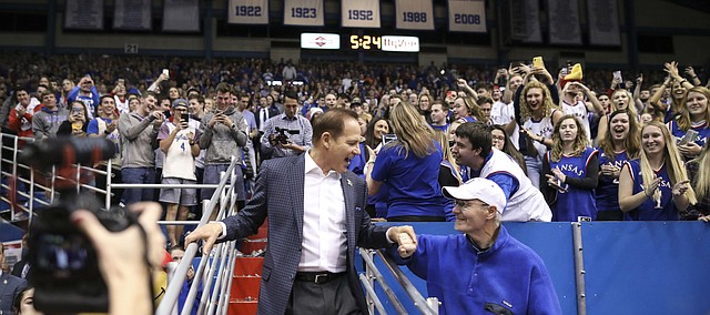 Newly-hired Kansas football coach Les Miles shakes hands with a fan as he is introduced to the Allen Fieldhouse crowd during halftime of the Jayhawks’ game against Stanford.
