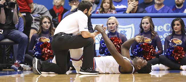 Kansas center Udoka Azubuike (35) lies on the ground with an injury as trainers come in to assist during the first half on Tuesday, Dec. 4, 2018 at Allen Fieldhouse.