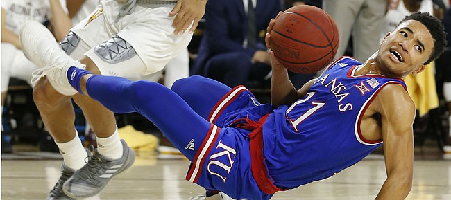 Kansas guard Devon Dotson (11) loses the ball in front of Arizona State guard Rob Edwards during the first half of an NCAA college basketball game Saturday, Dec. 22, 2018, in Tempe, Ariz. (AP Photo/Rick Scuteri)