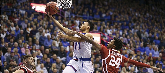 Kansas guard Devon Dotson (11) cruises in for a bucket past Oklahoma guard Jamal Bieniemy (24) during the first half, Wednesday, Jan. 2, 2019 at Allen Fieldhouse.