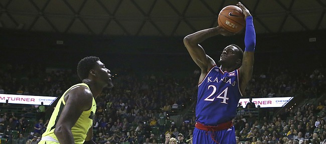 Kansas guard Lagerald Vick (24) shoots over Baylor guards Mark Vital (11) and Devonte Bandoo (2) in the second half of an NCAA college basketball game, Saturday, Jan. 12, 2019, in Waco, Texas. (AP Photo/Jerry Larson)