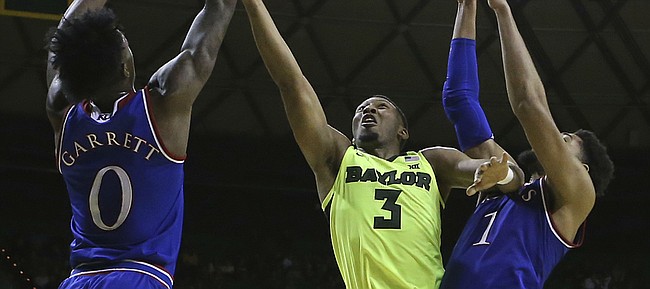 Baylor guard King McClure (3) is fouled by Kansas guard Marcus Garrett (0) as he attempts a shot against Kansas forward Dedric Lawson (1) in the second half of an NCAA college basketball game, Saturday, Jan. 12, 2019, in Waco, Texas. (AP Photo/Jerry Larson)