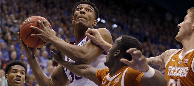 Kansas forward David McCormack shoots under pressure from Texas guard Courtney Ramey (3) and forward Dylan Osetkowski (21) during the first half of an NCAA college basketball game Monday, Jan. 14, 2019, in Lawrence, Kan. (AP Photo/Charlie Riedel)