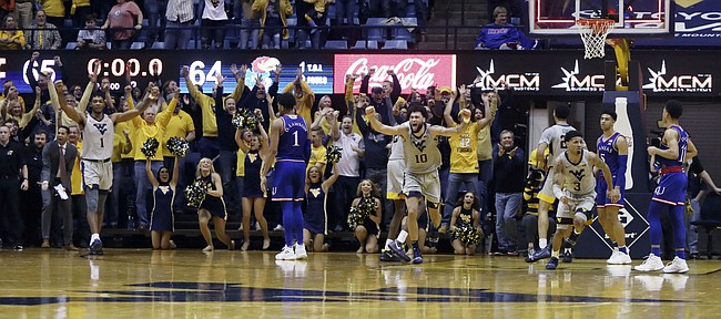 West Virginia players celebrates their 65-64 win over No 7 Kansas in an NCAA college basketball game, Saturday, Jan. 19, 2019, in Morgantown, W.Va.