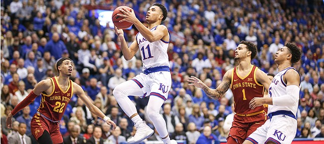 Kansas guard Devon Dotson (11) floats in to the bucket past Iowa State guard Tyrese Haliburton (22) and Iowa State guard Nick Weiler-Babb (1) during the first half, Monday, Jan. 21, 2019 at Allen Fieldhouse. At right is Kansas guard Quentin Grimes (5).