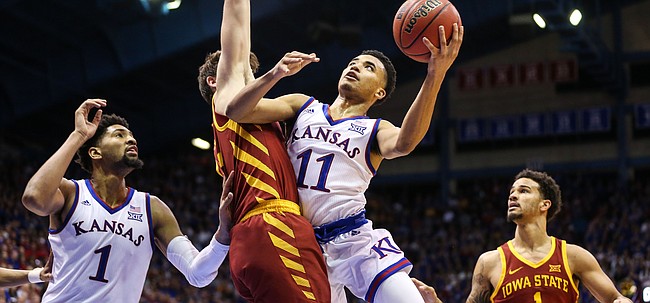 Kansas guard Devon Dotson (11) swoops in to the bucket against Iowa State forward Michael Jacobson (12) during the second half, Monday, Jan. 21, 2019 at Allen Fieldhouse.