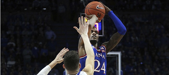 Kansas' Lagerald Vick (24) shoots while defended by Kentucky's Tyler Herro (14) during the second half of an NCAA college basketball game in Lexington, Ky., Saturday, Jan. 26, 2019. Kentucky won 71-63. (AP Photo/James Crisp)