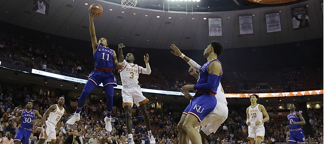 Kansas guard Devon Dotson (11) drives past Texas guard Courtney Ramey (3) to score during the first half on an NCAA college basketball game in Austin, Texas, Tuesday, Jan. 29, 2019. (AP Photo/Eric Gay)