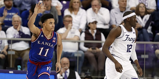Kansas guard Devon Dotson (11) celebrates sinking a 3-point basket in front of TCU forward Kouat Noi (12) in the second half of an NCAA college basketball game in Fort Worth, Texas, Monday, Feb. 11, 2019. 