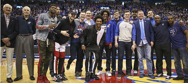 A host of former Jayhawk players come together for a photo after being introduced at half court during halftime, Saturday, Feb. 16, 2019 at Allen Fieldhouse.