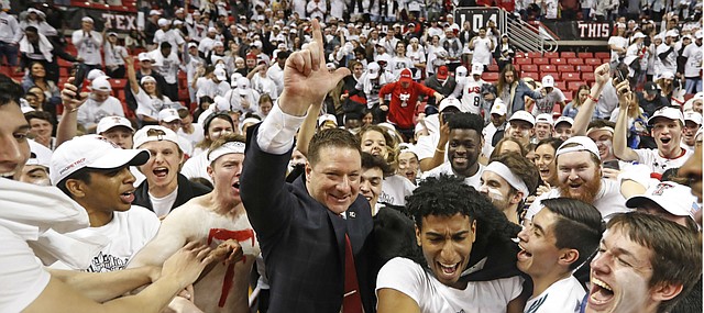 Texas Tech coach Chris Beard is surrounded by fans running onto the court after Texas Tech defeated Kansas 91-62 in an NCAA college basketball game Saturday, Feb. 23, 2019, in Lubbock, Texas. (AP Photo/Brad Tollefson)