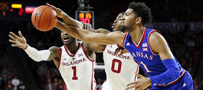 From left, Oklahoma guard Rashard Odomes (1), Oklahoma guard Christian James (0) and Kansas forward Dedric Lawson (1) chase a loose ball in the first half of an NCAA college basketball game in Norman, Okla., Tuesday, March 5, 2019. (AP Photo/Nate Billings)