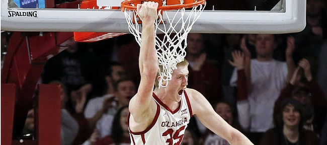 Oklahoma forward Brady Manek (35) reacts between Kansas forward Mitch Lightfoot (44) and guard Marcus Garrett (0) after a dunk in the first half of an NCAA college basketball game in Norman, Okla., Tuesday, March 5, 2019. (AP Photo/Nate Billings)