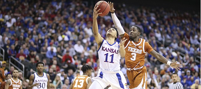 Kansas guard Devon Dotson (11) gets in to put up a shot past Texas guard Courtney Ramey (3) during the first half, Thursday, March 14, 2019 at Sprint Center in Kansas City, Mo.