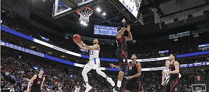 Kansas guard Devon Dotson (11) gets under the Northeastern defense for a bucket during the first half, Thursday, March 21, 2019 at Vivint Smart Homes Arena in Salt Lake City, Utah.
