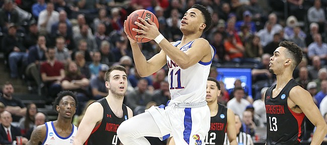 Kansas guard Devon Dotson (11) floats to the bucket past Northeastern guard Myles Franklin (13) during the second half, Thursday, March 21, 2019 at Vivint Smart Homes Arena in Salt Lake City, Utah.