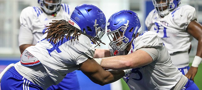 Kansas defensive lineman Codey Cole III, left, and nose tackle Sam Burt work on technique, Thursday, April 4, 2019, at the indoor practice facility.