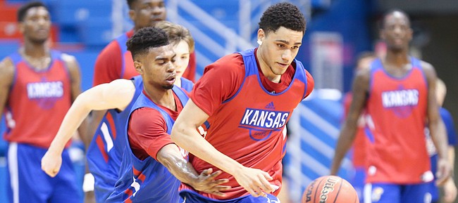 Kansas freshman Tristan Enaruna pushes the ball up the court as fellow freshman Isaac McBride defends during a scrimmage on Tuesday, June 11, 2019 at Allen Fieldhouse.