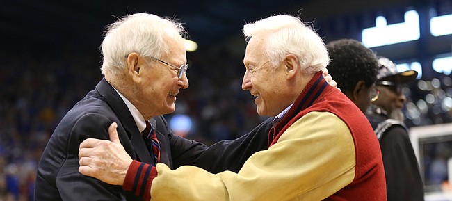 Ted Owens, left, is greeted by a former Kansas player during a halftime ceremony in recognition of 120 years of Kansas basketball.