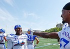 Kansas safety Mike Lee, center, and cornerback Elijah Jones have a laugh during a break from practice on Friday, Aug. 9, 2019.