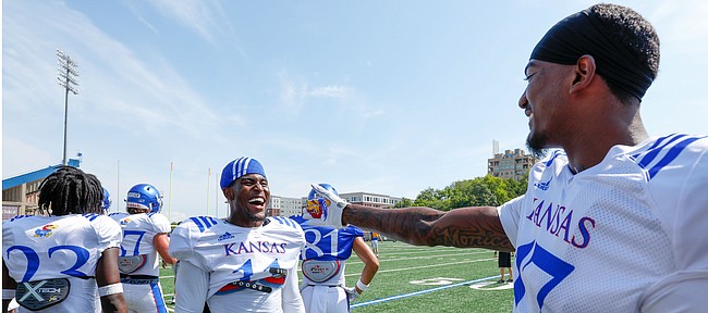 Kansas safety Mike Lee, center, and cornerback Elijah Jones have a laugh during a break from practice on Friday, Aug. 9, 2019.