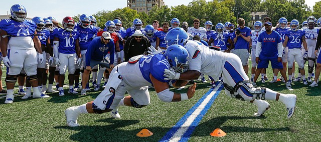 Kansas center Api Mane, left, and defensive tackle Jelani Brown go head-to-head in the Jayhawk drill during practice on Friday, Aug. 9, 2019.