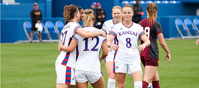 KU teammates Sophie Maierhofer (27), Katie McClure (12) and Ebba Costow (8) celebrate a goal during the team's 6-0 win over Loyola Chicago Sunday afternoon at Rock Chalk Park on Aug. 25, 2019.