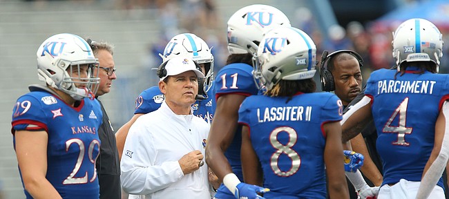 Kansas head coach Les Miles heads into the huddle with his team during the third quarter on Saturday, Sept. 21, 2019 at David Booth Kansas Memorial Stadium.