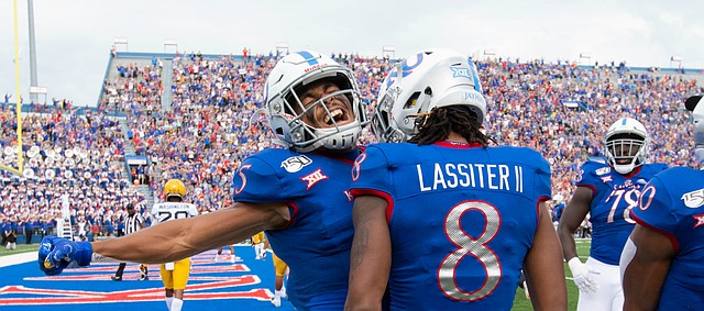Kansas wide receiver Stephon Robinson Jr. (5) left, and Kansas running back Khalil Herbert (10) come in to celebrate with Kansas wide receiver Kwamie Lassiter II (8) after Lassiter's touchdown during the second quarter on Saturday, Sept. 21, 2019 at David Booth Kansas Memorial Stadium.